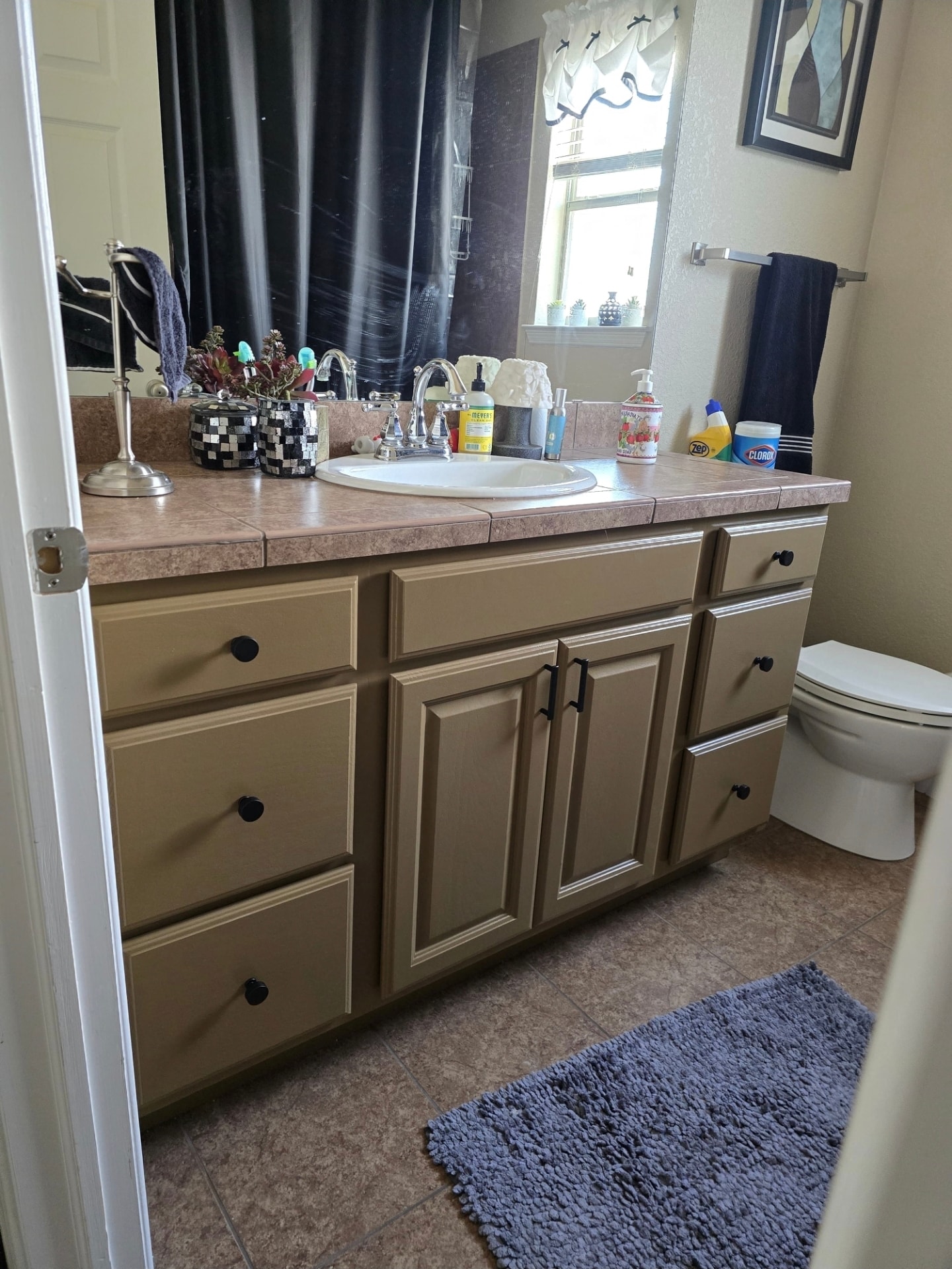 Refinished tan bathroom vanity cabinets with tile countertop and black hardware