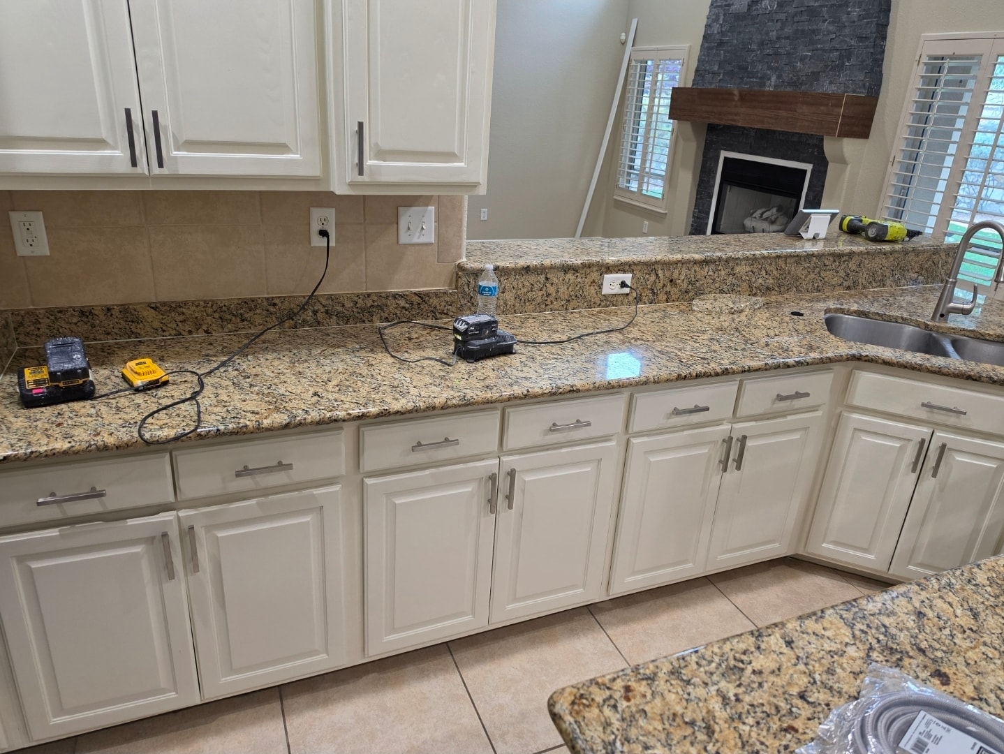 Refinished white kitchen cabinets with granite countertops