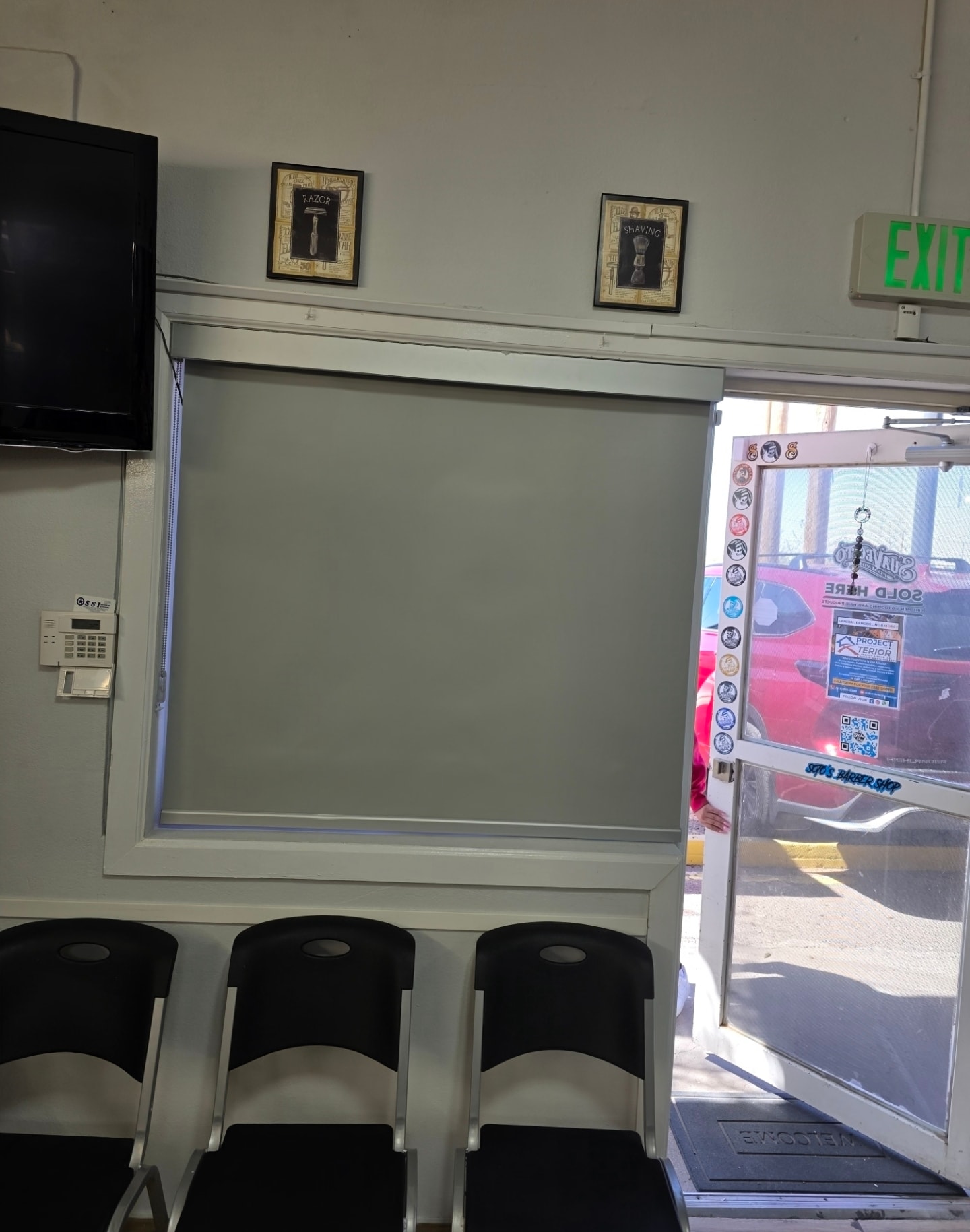 Gray roller shade on a commercial barbershop window