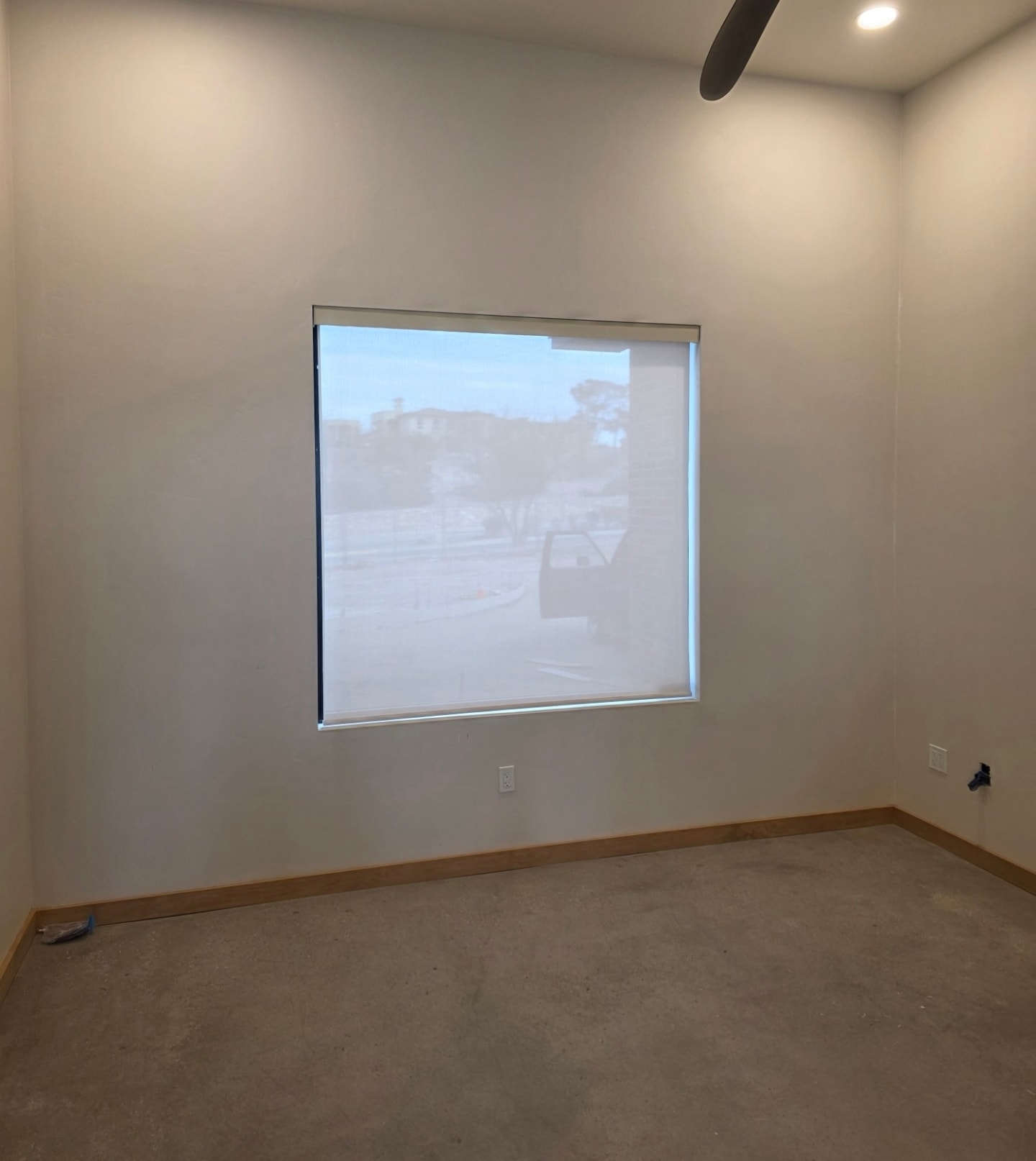 Sheer white roller shade on a large bedroom window