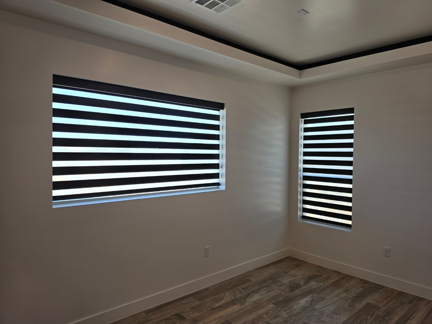 Bold black zebra shades on two bedroom windows