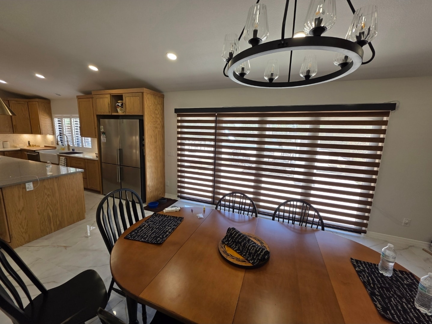 Walnut-tone zebra shades open on a dining room window